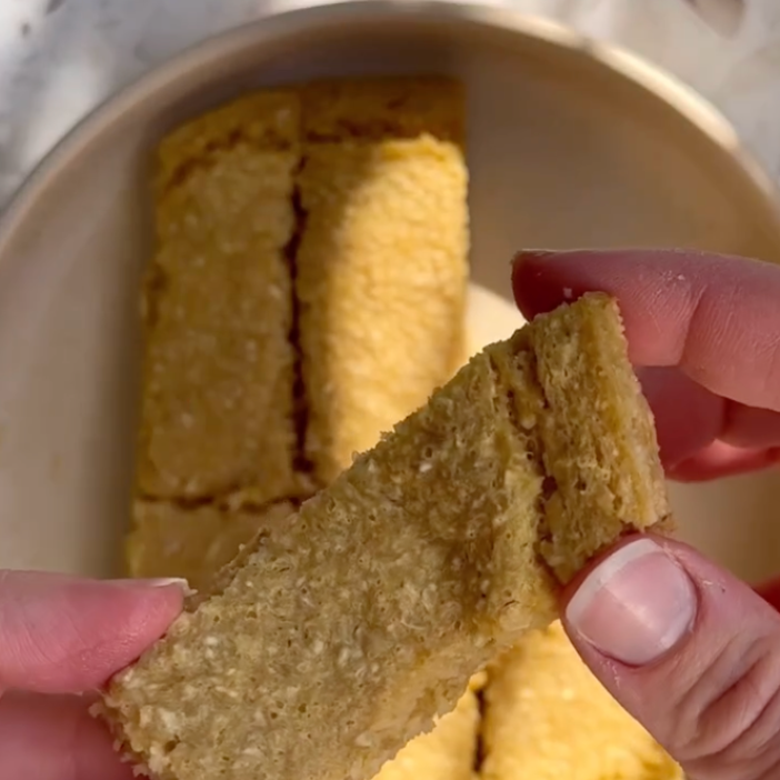 Hand holding golden-brown textured snack bar, ideal for mess-free mealtime