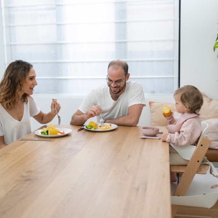 Family enjoying mess-free meal with food-catching mat, protecting floors and simplifying cleanup