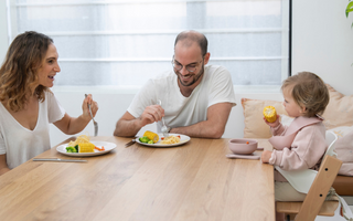 Family enjoying mess-free meal with food-catching mat, protecting floors and simplifying cleanup
