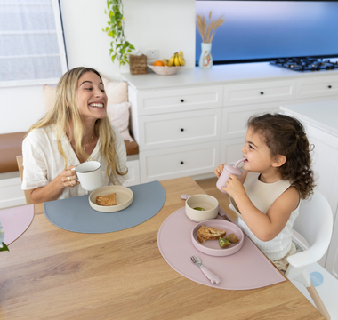 Mom and toddler eating at table with mess-free silicone placemats, easy clean food catcher for meals