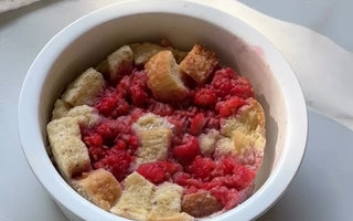 Raspberry bread pudding in white ramekin, fresh baked dessert with juicy berries and golden cubes