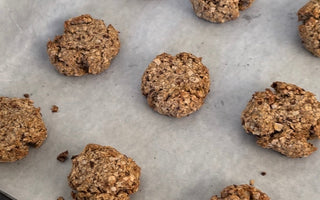 Freshly baked oatmeal cookies on parchment paper, perfect for mess-free snacking with CATCHY.