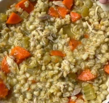 Hearty chicken barley soup with carrots and celery in a white bowl, perfect for mess-free meals.